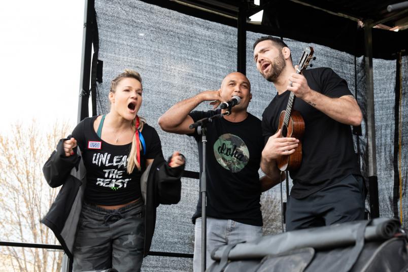 UFC athletes Felice Herrig, BJ Penn and Chris Weidman sing during a leg of the USO Tour overseas (DoD Photo by U.S. Army Sgt. James K. McCann).