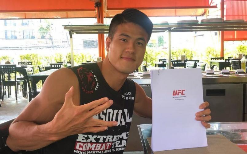 Sungbin Jo poses with his newly signed UFC contract (image from Jo's Instagram @koreanfalcon).
