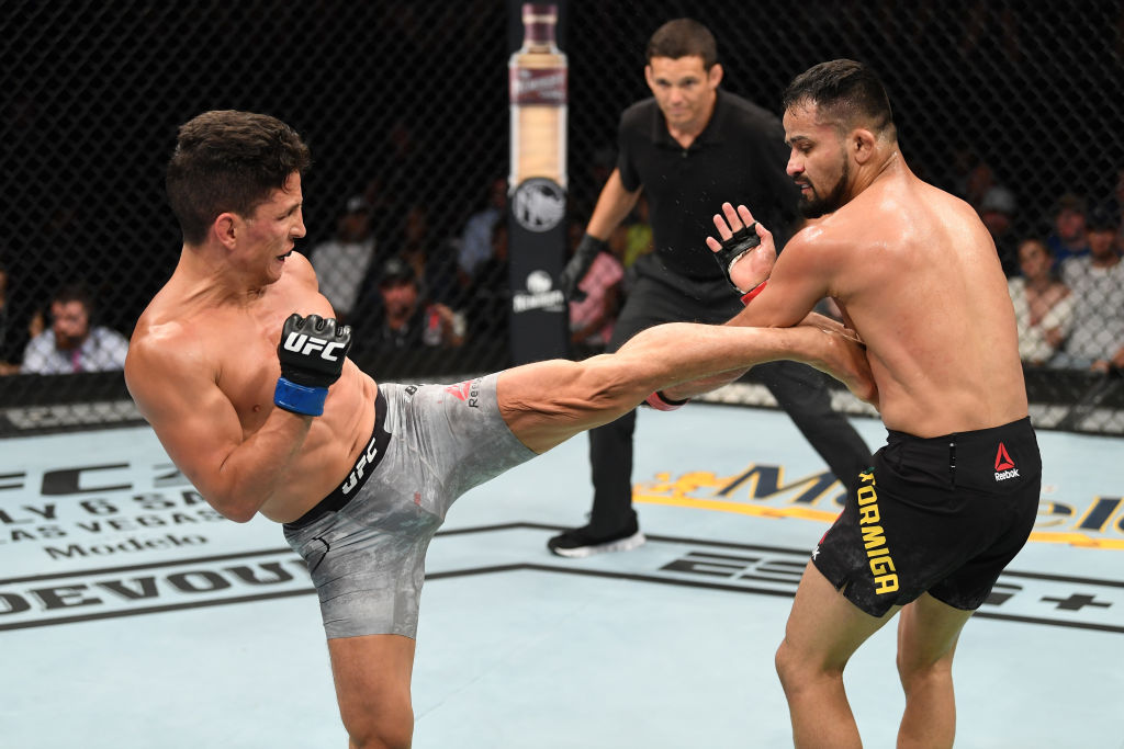 MINNEAPOLIS, MN - JUNE 29: (L-R) Joseph Benavidez kicks Jussier Formiga of Brazil in their flyweight bout during the UFC Fight Night