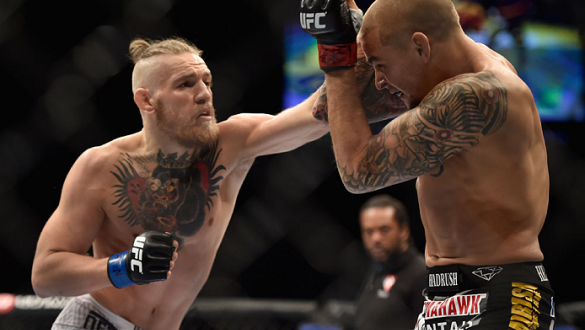LAS VEGAS, NV - SEPTEMBER 27:  (L-R) Conor McGregor punches Dustin Poirier in their featherweight fight during the UFC 178 event inside the MGM Grand Garden Arena on September 27, 2014 in Las Vegas, Nevada.  (Photo by Jeff Bottari/Zuffa LLC/Zuffa LLC via 