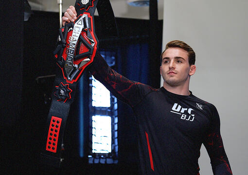 Andrew Tackett holds up his UFC BJJ championship belt