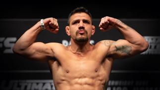 Rafael Dos Anjos steps on the scales at weigh-ins