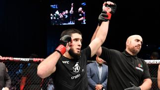 Islam Makhachev tem o braço erguido ao ser declarado vencedor da luta com Dan Hooker no UFC 267