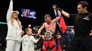 Petr Yan recebe o cinturão do UFC com o braço erguido pelo árbitro após vencer Cory Sandhagen no UFC 267