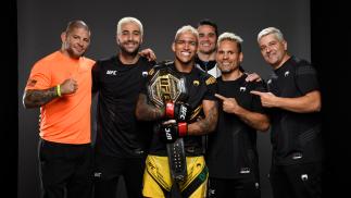 Charles Oliveira posa com sua equipe e com o cinturão após vencer Michael Chandler no UFC 262