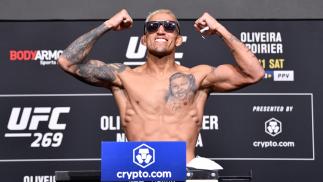 Charles do Bronx posa flexionando os braços e de óculos escuros na pesagem do UFC 269
