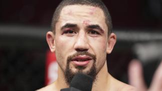 Robert Whittaker of Australia speaks to Daniel Cormier after his loss to Israel Adesanya at UFC 271: Adesanya vs Whittaker 2