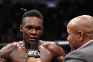 Israel Adesanya of Nigeria is interviewed by Daniel Cormier after defeating Robert Whittaker of Australia in their UFC middleweight championship fight during the UFC 271 event at Toyota Center on February 12, 2022 in Houston, Texas. (Photo by Josh Hedges/Zuffa LLC)