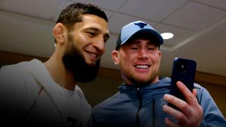 Khamzat Chimaev and Darren Till look at a phone.