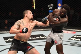 ABU DHABI, UNITED ARAB EMIRATES - OCTOBER 25: (L-R) Robert Whittaker of Australia punches Jared Cannonier