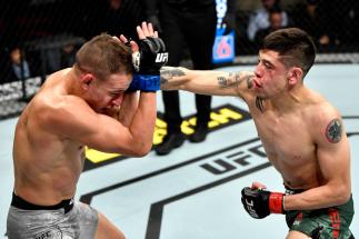 LAS VEGAS, NEVADA - DECEMBER 14: (R-L) Brandon Moreno of Mexico strikes Kai Kara-France of New Zealand in their flyweight bout during the UFC 245