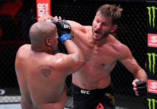 LAS VEGAS, NEVADA - AUGUST 15: In this handout image provided by UFC, Stipe Miocic (R) punches Daniel Cormier in their UFC heavyweight championship bout during the UFC 252