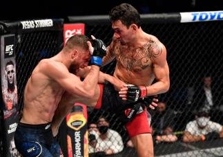 ABU DHABI, UNITED ARAB EMIRATES - JANUARY 17: (L-R) Max Holloway kicks Calvin Kattar in a featherweight bout during the UFC Fight Night 