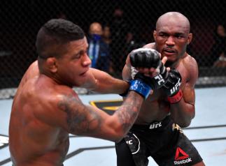 LAS VEGAS, NEVADA - FEBRUARY 13: In this handout image provided by UFC, (R-L) Kamaru Usman of Nigeria punches Gilbert Burns of Brazil in their UFC welterweight championship fight during the UFC 258