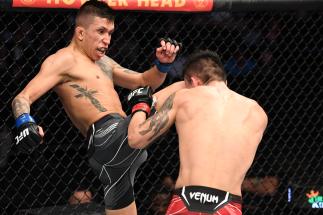 JACKSONVILLE, FLORIDA - APRIL 24: (L-R) Jeff Molina kicks Aoriqileng of China in their flyweight bout during the UFC 261