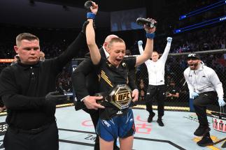 Rose Namajunas reacts after defeating Zhang Weili of China in their UFC women's strawweight championship bout as UFC President Dana White places the championship belt on her during the UFC 261