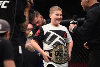 LAS VEGAS, NV - DECEMBER 30: Cody Garbrandt (back) places the UFC title belt around a young fan's wasit after defeating Dominick Cruz in their UFC bantamweight championship bout during the UFC 207 event at T-Mobile Arena on December 30, 2016 in Las Vegas,