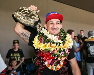 Max Holloway foi recebido com muita festa no retorno a sua terra natal. O agora campeão linear dos penas desembarcou no Havaí nesta segunda-feira e foi surpreendido no aeroporto por uma multidão de fãs a sua espera. O lutador distribuiu autógrafos, fotos