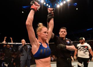 SINGAPORE - JUNE 17:   Holly Holm celebrates after her knockout victory over Bethe Correia of Brazil in their women's bantamweight bout during the UFC Fight Night event at the Singapore Indoor Stadium on June 17, 2017 in Singapore. (Photo by Brandon Magnu