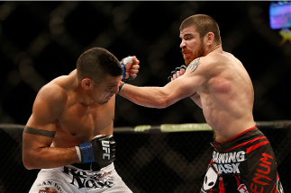 LAS VEGAS, NV - DECEMBER 28: (R-L) Jim Miller punches Fabricio Camoes in their lightweight bout during the UFC 168 event at the MGM Grand Garden Arena on December 28, 2013 in Las Vegas, Nevada. (Photo by Josh Hedges/Zuffa LLC/Zuffa LLC via Getty Images)