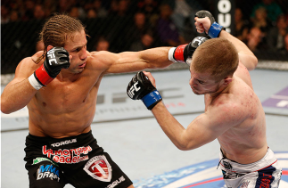 SACRAMENTO, CA - DECEMBER 14:  (L-R) Urijah Faber punches Michael McDonald in their bantamweight bout during the UFC on FOX event at Sleep Train Arena on December 14, 2013 in Sacramento, California. (Photo by Josh Hedges/Zuffa LLC/Zuffa LLC via Getty Imag