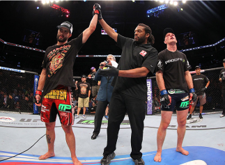 INDIANAPOLIS, IN - AUGUST 28: Carlos Condit (L) reacts after his TKO victory over Martin Kampmann in their welterweight fight during the UFC on FOX Sports 1 event at Bankers Life Fieldhouse on August 28, 2013 in Indianapolis, Indiana. (Photo by Ed Mulhol