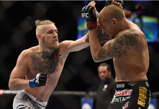 LAS VEGAS, NV - SEPTEMBER 27: (L-R) Conor McGregor punches Dustin Poirier in their featherweight fight during the UFC 178 event inside the MGM Grand Garden Arena on September 27, 2014 in Las Vegas, Nevada. (Photo by Jeff Bottari/Zuffa LLC/Zuffa LLC via