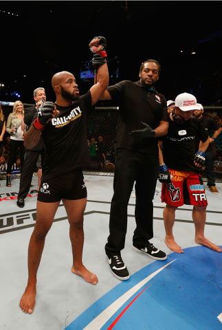 LAS VEGAS, NV - SEPTEMBER 27: (L-R)UFC Flyweight champion Demetrious Johnson celebrates after his win over Chris Cariaso after their flyweight championship fight during the UFC 178 event inside the MGM Grand Garden Arena on September 27, 2014 in Las Vega