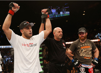 LAS VEGAS, NV - JANUARY 03: (L-R) Brad Tavares celebrates his win over Nate Marquardt after their middleweight bout during the UFC 182 event at the MGM Grand Garden Arena on January 3, 2015 in Las Vegas, Nevada. (Photo by Josh Hedges/Zuffa LLC/Zuffa LLC