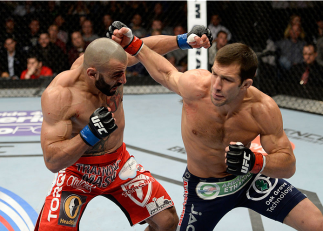 DULUTH, GA - JANUARY 15:  (R-L) Luke Rockhold punches Costas Philippou in their middleweight fight during the UFC Fight Night event inside The Arena at Gwinnett Center on January 15, 2014 in Duluth, Georgia.  (Photo by Jeff Bottari/Zuffa LLC/Zuffa LLC via