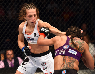 PHOENIX, AZ - DECEMBER 13: (R-L) Claudia Gadelha of Brazil punches Joanna Jedrzejczyk of Poland in their women's strawweight fight during the UFC Fight Night event at the U.S. Airways Center on December 13, 2014 in Phoenix, Arizona. (Photo by Josh Hedge