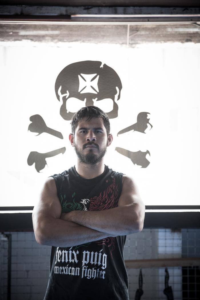 Juan Puig posa frente al logo de Bonebreakers. Juan debutó en UFC como peso ligero, pero ha bajado de división y se estrenará como peso pluma en UFC Fight Night Austin.