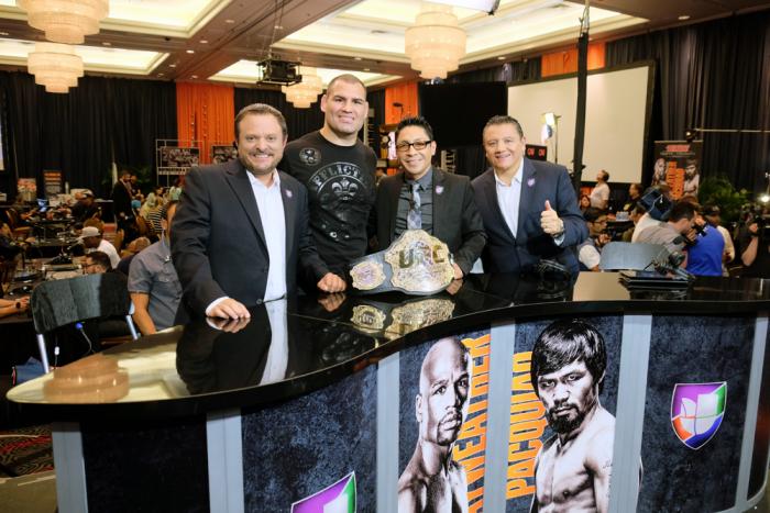 Cain Velasquez posa con la mesa de Univisión Deportes donde comentó sobre la pelea Mayweather-Pacquiao.