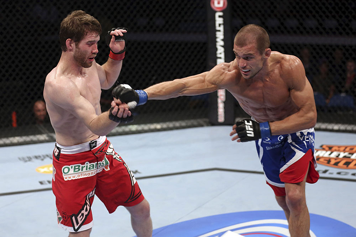 CALGARY, CANADA - JULY 21:  (R-L) Anton Kuivanen throws a punch at Mitch Clarke during their lightweight bout at UFC 149 inside the Scotiabank Saddledome on July 21, 2012 in Calgary, Alberta, Canada.  (Photo by Nick Laham/Zuffa LLC/Zuffa LLC via Getty Ima