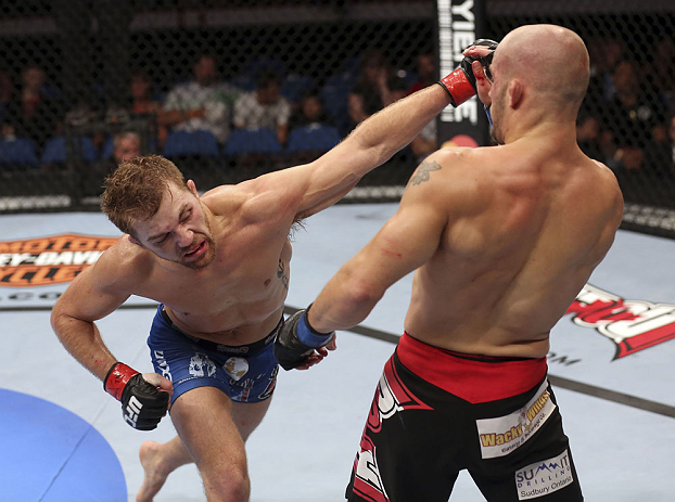 CALGARY, CANADA - JULY 21: (L-R) Bryan Caraway lands a punch on Mitch Gagnon during their bantamweight bout at UFC 149 inside the Scotiabank Saddledome on July 21, 2012 in Calgary, Alberta, Canada.  (Photo by Nick Laham/Zuffa LLC/Zuffa LLC via Getty Image