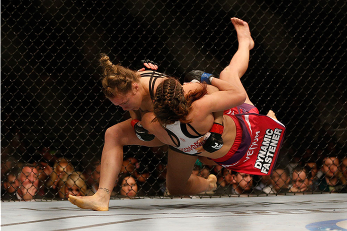 LAS VEGAS, NV - DECEMBER 28:  (L-R) Ronda Rousey throws Miesha Tate in their UFC women's bantamweight championship bout during the UFC 168 event at the MGM Grand Garden Arena on December 28, 2013 in Las Vegas, Nevada. (Photo by Josh Hedges/Zuffa LLC/Zuffa