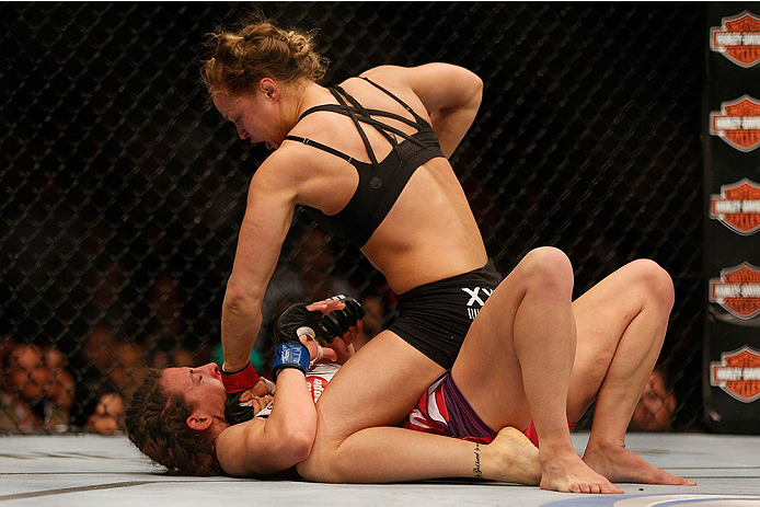 LAS VEGAS, NV - DECEMBER 28:  Ronda Rousey (top) punches Miesha Tate in their UFC women's bantamweight championship bout during the UFC 168 event at the MGM Grand Garden Arena on December 28, 2013 in Las Vegas, Nevada. (Photo by Josh Hedges/Zuffa LLC/Zuff