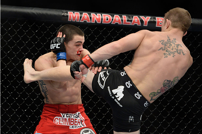 LAS VEGAS, NV - NOVEMBER 30:  (R-L) Josh Sampo kicks Ryan Benoit in their flyweight fight during The Ultimate Fighter season 18 live finale inside the Mandalay Bay Events Center on November 30, 2013 in Las Vegas, Nevada. (Photo by Jeff Bottari/Zuffa LLC/Z