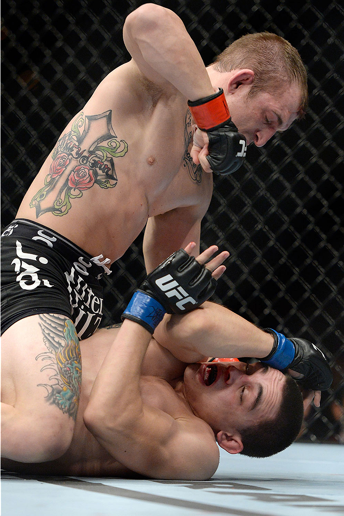 LAS VEGAS, NV - NOVEMBER 30:  Josh Sampo (black shorts) punches Ryan Benoit in their flyweight fight during The Ultimate Fighter season 18 live finale inside the Mandalay Bay Events Center on November 30, 2013 in Las Vegas, Nevada. (Photo by Jeff Bottari/