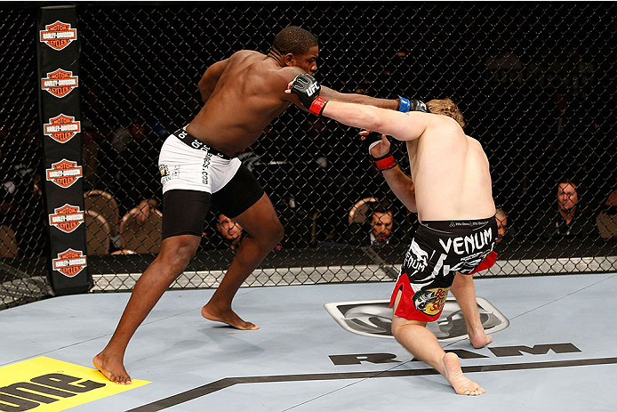 LAS VEGAS, NV - NOVEMBER 30:  (L-R) Walt Harris punches Jared Rosholt in their heavyweight fight during The Ultimate Fighter season 18 live finale inside the Mandalay Bay Events Center on November 30, 2013 in Las Vegas, Nevada. (Photo by Josh Hedges/Zuffa