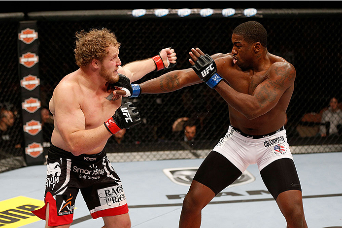 LAS VEGAS, NV - NOVEMBER 30:  (L-R) Jared Rosholt punches Walt Harris in their heavyweight fight during The Ultimate Fighter season 18 live finale inside the Mandalay Bay Events Center on November 30, 2013 in Las Vegas, Nevada. (Photo by Josh Hedges/Zuffa