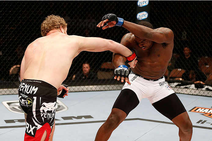 LAS VEGAS, NV - NOVEMBER 30:  (L-R) Jared Rosholt punches Walt Harris in their heavyweight fight during The Ultimate Fighter season 18 live finale inside the Mandalay Bay Events Center on November 30, 2013 in Las Vegas, Nevada. (Photo by Josh Hedges/Zuffa