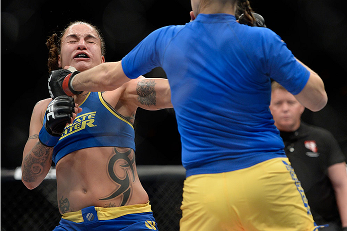 LAS VEGAS, NV - NOVEMBER 30: (L-R) Raquel Pennington gets punched by Roxanne Modafferi in their women's bantamweight fight during The Ultimate Fighter season 18 live finale inside the Mandalay Bay Events Center on November 30, 2013 in Las Vegas, Nevada.