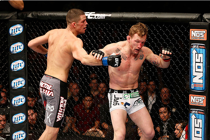 LAS VEGAS, NV - NOVEMBER 30:  (L-R) Nate Diaz punches Gray Maynard in their lightweight fight during The Ultimate Fighter season 18 live finale inside the Mandalay Bay Events Center on November 30, 2013 in Las Vegas, Nevada. (Photo by Josh Hedges/Zuffa LL