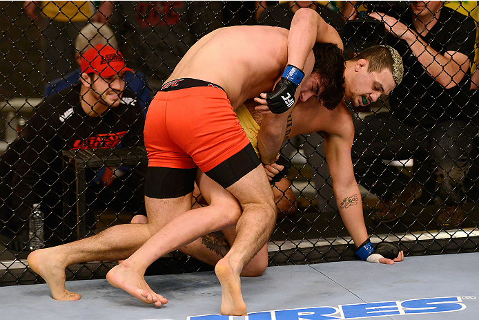 LACHUTE, CANADA - DECEMBER 6:  (L-R) Team Canada fighter Elias Theodorou takes down Team Australia fighter Tyler Manawaroa in their semifinal middleweight fight during filming of The Ultimate Fighter Nations television series on December 6, 2013 in Lachut