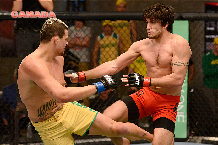 LACHUTE, CANADA - DECEMBER 6:  (L-R) Team Australia fighter Tyler Manawaroa kicks Team Canada fighter Elias Theodorou in their semifinal middleweight fight during filming of The Ultimate Fighter Nations television series on December 6, 2013 in Lachute, Qu