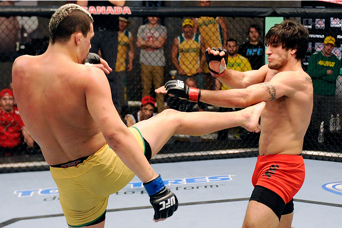 LACHUTE, CANADA - DECEMBER 6:  (L-R) Team Australia fighter Tyler Manawaroa kicks Team Canada fighter Elias Theodorou in their semifinal middleweight fight during filming of The Ultimate Fighter Nations television series on December 6, 2013 in Lachute, Qu