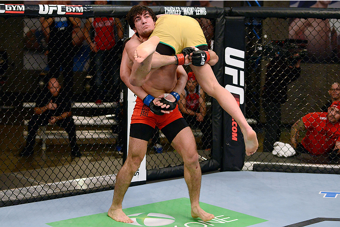 LACHUTE, CANADA - DECEMBER 6:  (L-R) Team Canada fighter Elias Theodorou takes down Team Australia fighter Tyler Manawaroa in their semifinal middleweight fight during filming of The Ultimate Fighter Nations television series on December 6, 2013 in Lachut