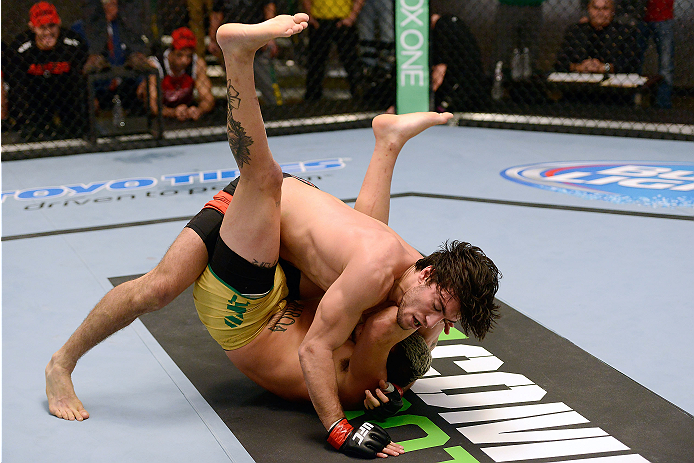 LACHUTE, CANADA - DECEMBER 6:  (L-R) Team Canada fighter Elias Theodorou takes down Team Australia fighter Tyler Manawaroa in their semifinal middleweight fight during filming of The Ultimate Fighter Nations television series on December 6, 2013 in Lachut