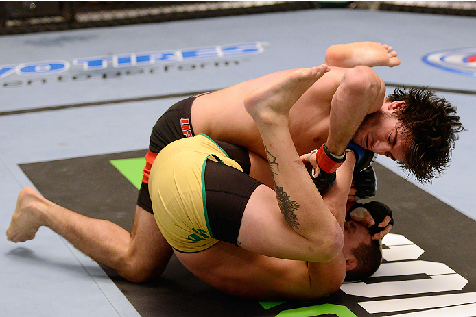 LACHUTE, CANADA - DECEMBER 6:  (L-R) Team Canada fighter Elias Theodorou takes down Team Australia fighter Tyler Manawaroa in their semifinal middleweight fight during filming of The Ultimate Fighter Nations television series on December 6, 2013 in Lachut